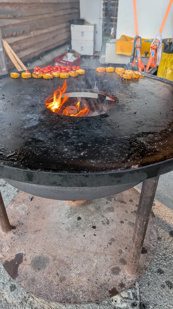 Feuerring mit Maiskolben und Tomaten