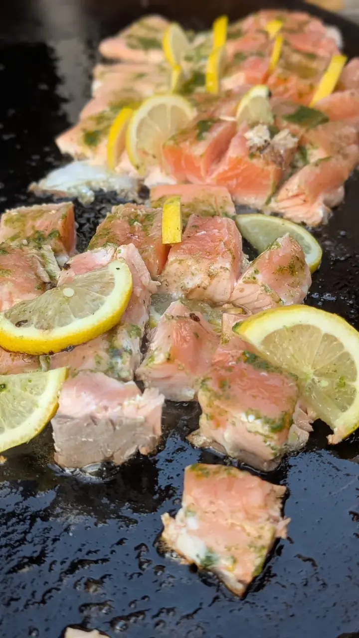 Lachsstücke mit Zitronenscheiben auf der Grillplatte
