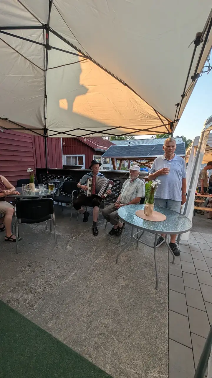 Akkordeonspieler in Tracht musiziert unter dem Pavillon